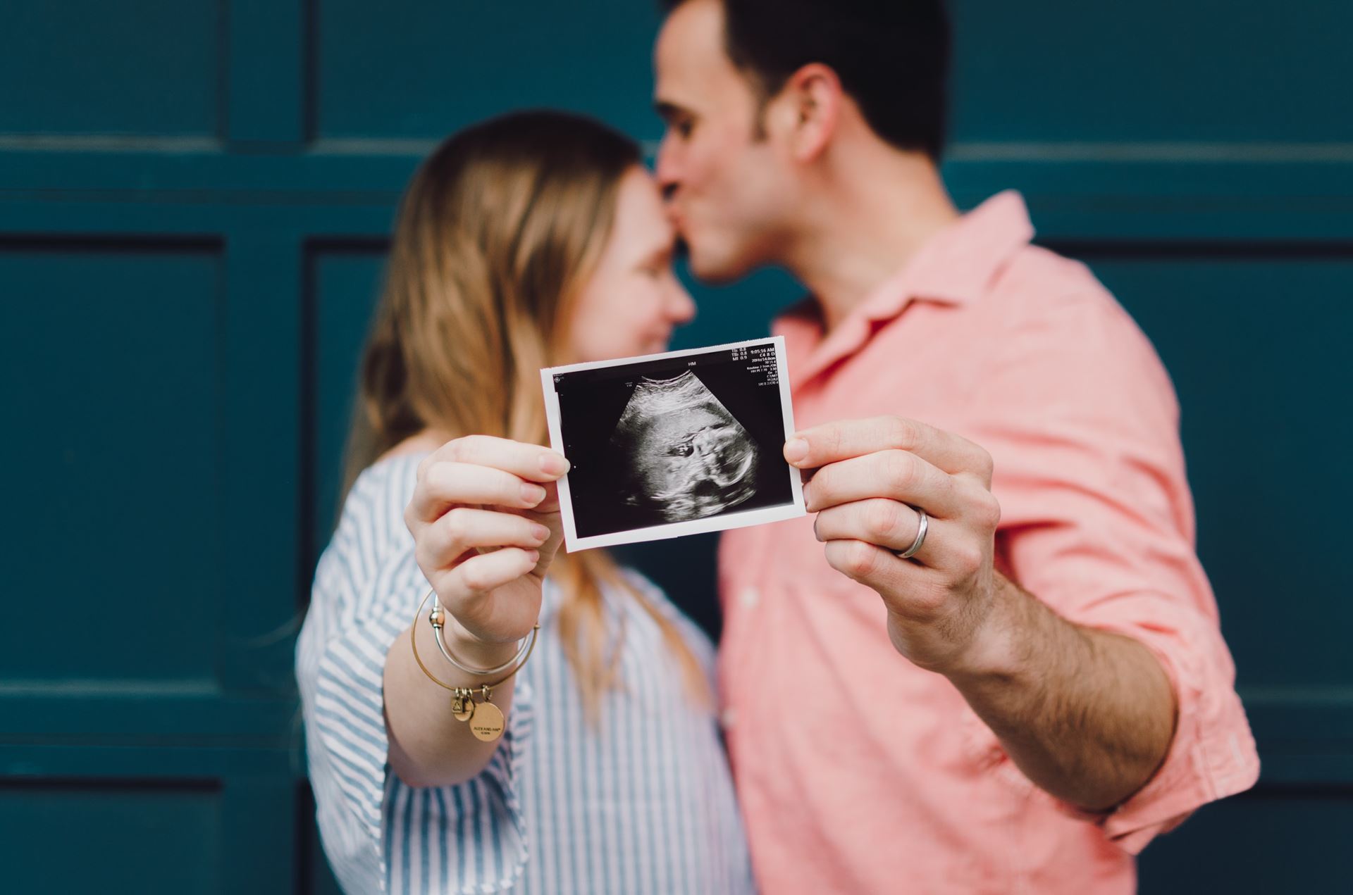 A couple holding a baby scan picture